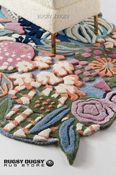 a rug with flowers on it and a white chair in the background that says ruggy dusty