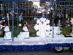 a parade float with snowmen and people on it