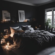 a dark bedroom with candles lit up on the bed