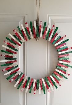 a wreath made out of popsicle sticks is hanging on the front door, decorated with red and green sprinkles