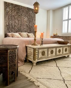 a bed room with a neatly made bed and two candles on the end tables next to it