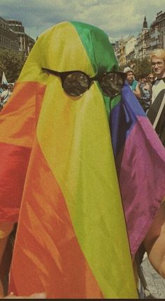 a person wearing sunglasses and a rainbow colored scarf