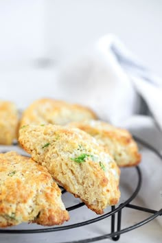 four biscuits on a wire rack with a white napkin in the backgroung