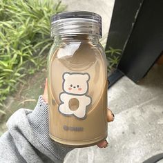 a person holding a glass jar with a bear on it