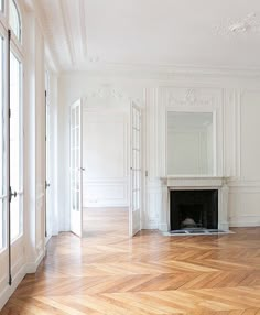 an empty room with white walls and wood floors