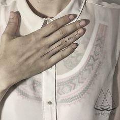 a woman with her hand on her chest holding the other side of her neck and wearing a ring