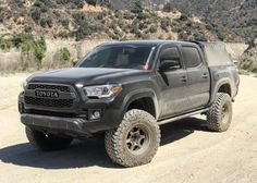 a gray toyota truck parked on top of a dirt road