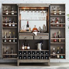 an open cabinet filled with bottles and glasses