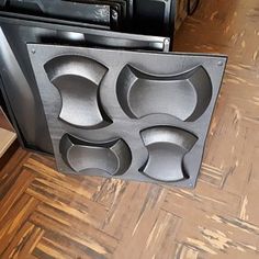 a black stove top oven sitting on top of a wooden floor next to a microwave