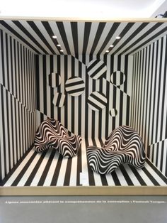 two black and white striped beds in a room with an abstract design on the wall