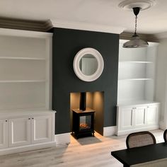 a living room filled with furniture and a fire place next to a wall mounted book shelf