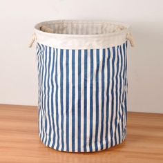 a large blue and white striped storage bag on a wooden table with measurements for the size