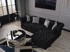 a living room filled with black couches and pillows