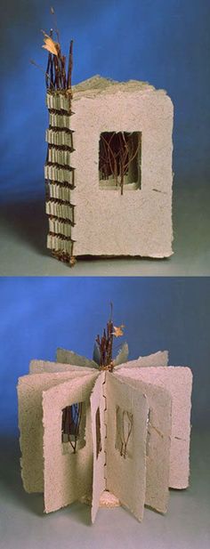 an open book that is made to look like a house with windows and branches sticking out of it