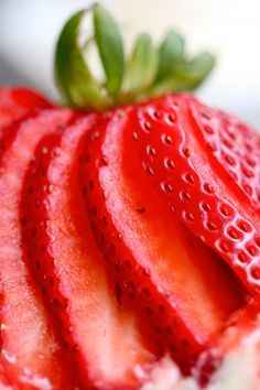 closeup of sliced strawberries with green leaves on top