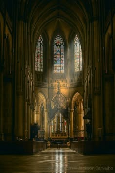 an empty cathedral with stained glass windows and pews on the floor, as seen from the front