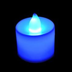 a blue candle lit up in the dark