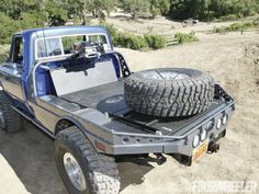 an off road truck with two large tires on the bed