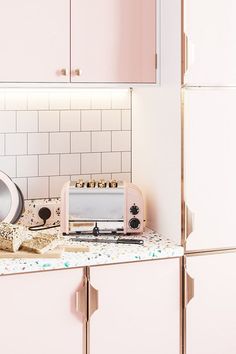 a kitchen with pink appliances and confetti on the counter