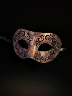 Crafted with intricate engraved patterns on soft vegan leather, this mask is a masterpiece of artistry that adds an air of mystique to your masquerade ensemble. Embrace the allure of engraved elegance and captivate hearts with your enigmatic presence at masquerades and special events! Age Group/Gender - Adult/Men Size/Type - One size fits all adults Mask Color - Copper Mask Material - Vegan Leather Gothic Adjustable Masquerade Mask, Venetian Formal Eye Mask, Adjustable Mask For Masquerade, Formal Venetian Eye Mask For Masquerade, Venetian Masquerade Mask For Halloween Formal, Venetian Style Formal Eye Masquerade Mask, Vintage Eye Mask For Parties, Vintage Eye Mask For Party, Vintage Eye Masquerade Mask For Party