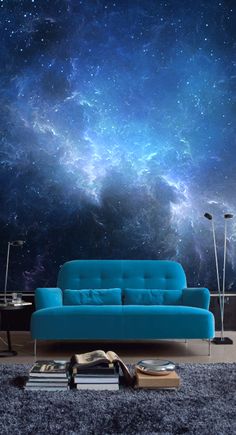 a blue couch sitting on top of a rug in front of a wall covered in stars