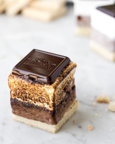 a piece of cake sitting on top of a counter next to other desserts and cookies