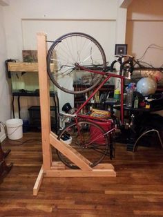 an old bicycle is being worked on in a room with wooden floors and hard wood flooring