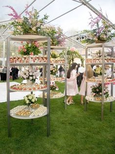 two people standing in front of an assortment of desserts on display at a wedding