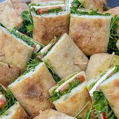 a plate full of sandwiches with toothpicks stuck in the bread and lettuce