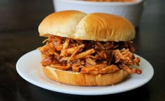 a pulled pork sandwich on a white plate