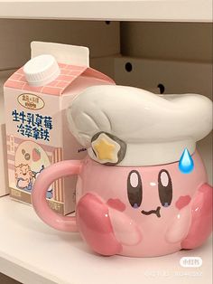 a pink cup with a chef hat on top of it next to a carton of milk