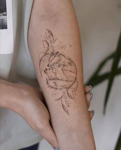 a woman's arm with a tattoo on it that has an image of a wolf