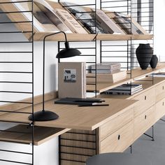 a wooden desk topped with books and a lamp