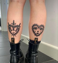 two tattoos on the legs of a person with black boots and an ornate frame in the shape of a heart