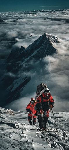 two people walking up the side of a mountain