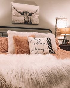 a bedroom with a cow head on the wall next to a white bed and pillows