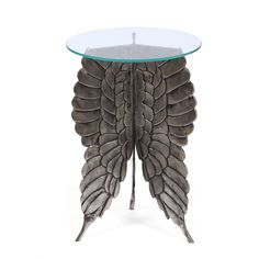 a glass and metal table with a large bird's wing design on the top