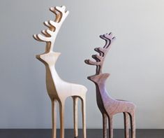 three wooden deer sculptures sitting next to each other