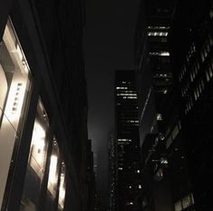 an empty city street at night with tall buildings