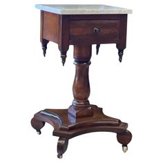 an old wooden table with marble top and legs on wheels, isolated against a white background