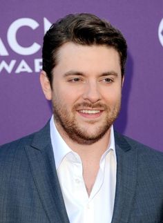 a man in a suit and white shirt smiling for the camera at an awards event