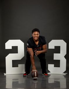 a football player poses for a photo in front of the number 32 sign with his foot