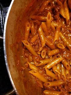 a pot filled with pasta and sauce on top of a stove