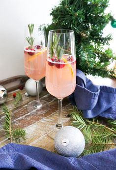 two glasses filled with pink wine and garnished with rosemary