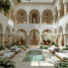 an indoor swimming pool in the middle of a large room with white furniture and flowers