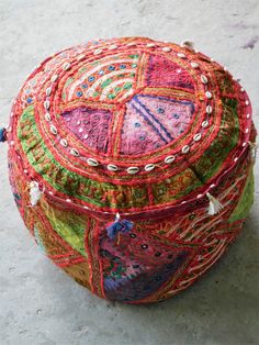 a multicolored patchwork round ottoman with tassels