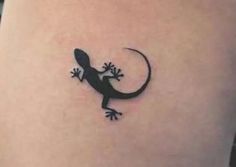 a small lizard tattoo on the side of a woman's stomach