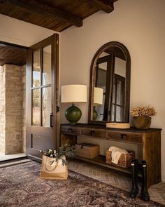 a room with a rug, mirror and vase on the floor in front of it