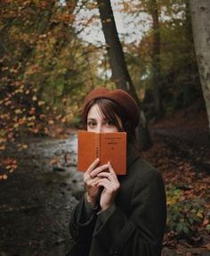 a woman holding an open book in front of her face