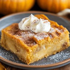 a piece of pie on a plate with whipped cream and pumpkins in the background